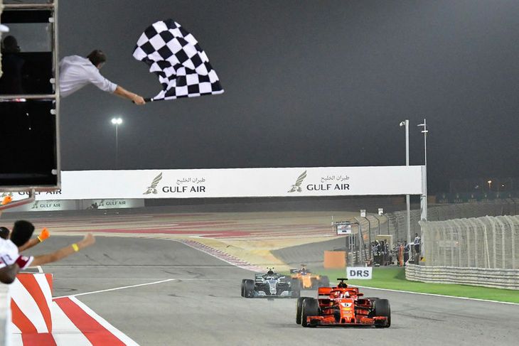 Sigurflagginu veifað er Sebastian Vettel kemur á endamark í kappakstrinum í Barein. Rétt á eftir ...